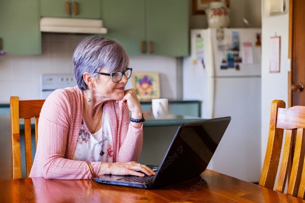 AN ELDERLY LADY SIGNING UP FOR CAN PRO SOLUTIONS SERVICE